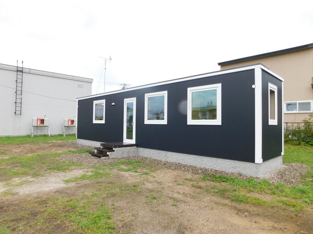 窓枠や辺にあたる部分が白く、他は黒色になっている直方体の建物の写真