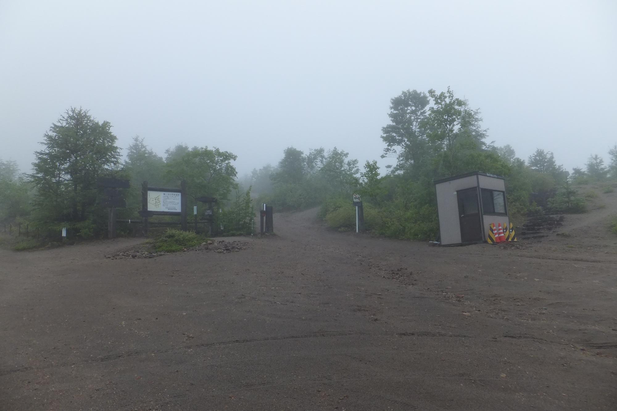 看板や小さな小屋がある登山口の写真