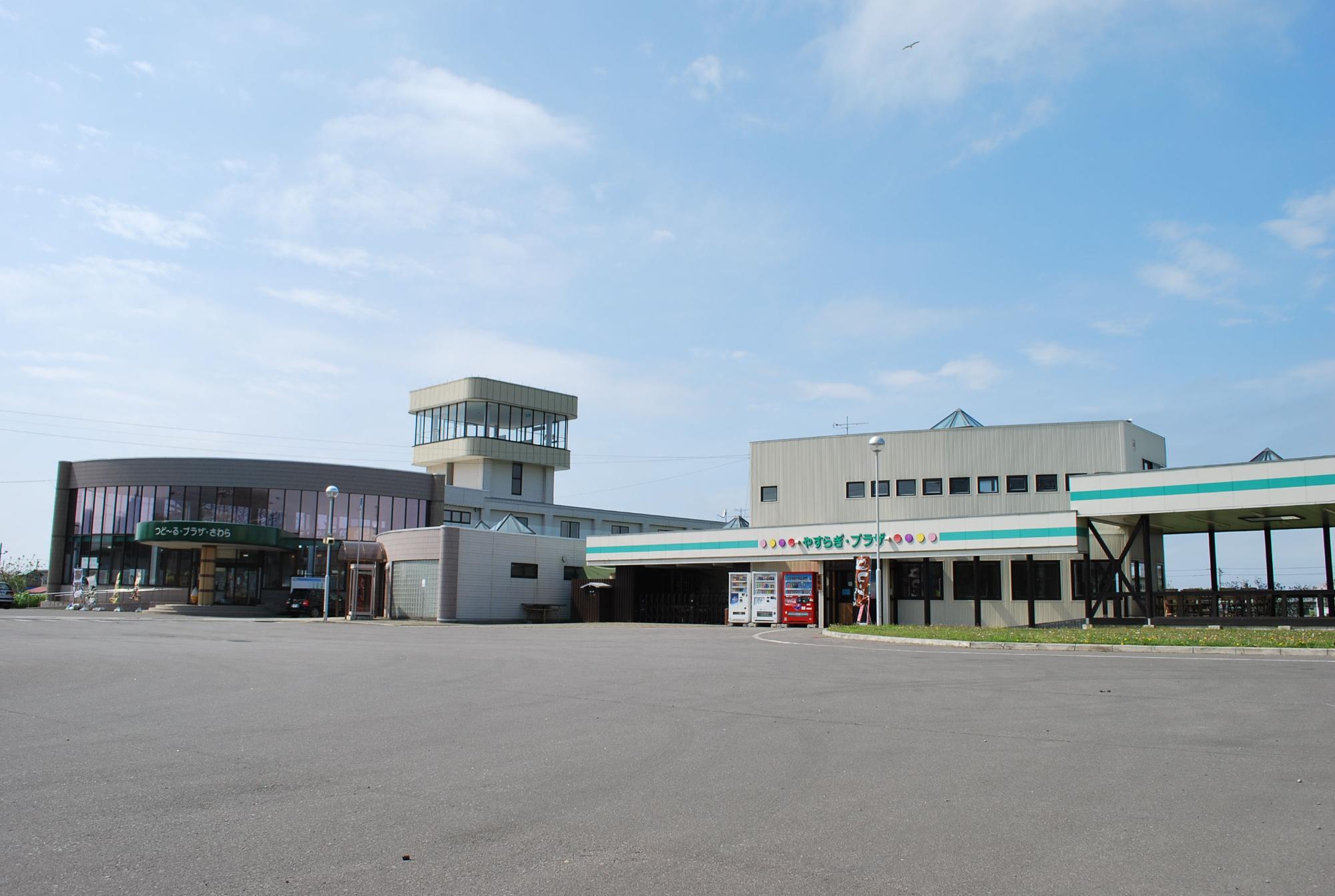 半円形になった全面にガラスが貼られた黒い建物と、グレーの建物が繋がっている建物外観の写真