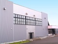 格子状の窓があるグレーと白を基調とした四角い建物外観の写真